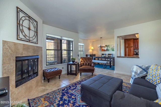 living room featuring a notable chandelier, a tiled fireplace, and light tile patterned flooring