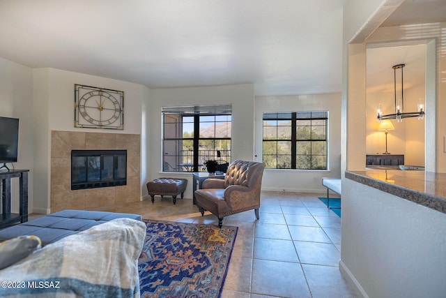 living room featuring a tiled fireplace and light tile patterned floors