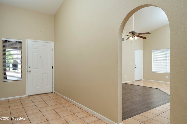 entrance foyer featuring a healthy amount of sunlight, ceiling fan, high vaulted ceiling, and light hardwood / wood-style floors