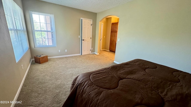 bedroom featuring a textured ceiling and carpet floors