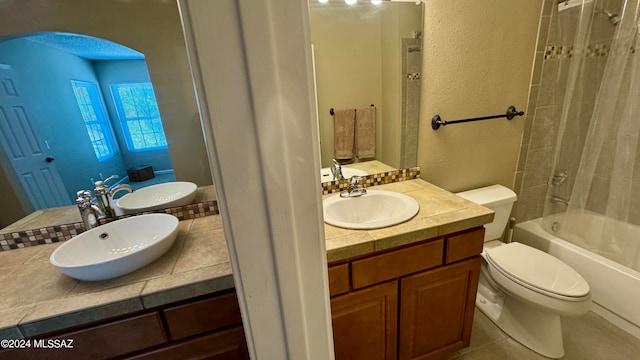 full bathroom with tiled shower / bath, vanity, toilet, and tile patterned flooring