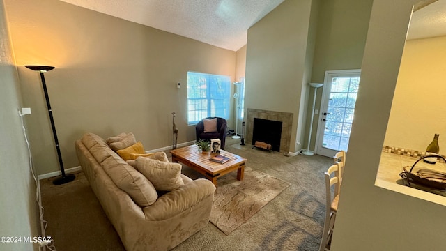 carpeted living room with high vaulted ceiling, a fireplace, and a textured ceiling