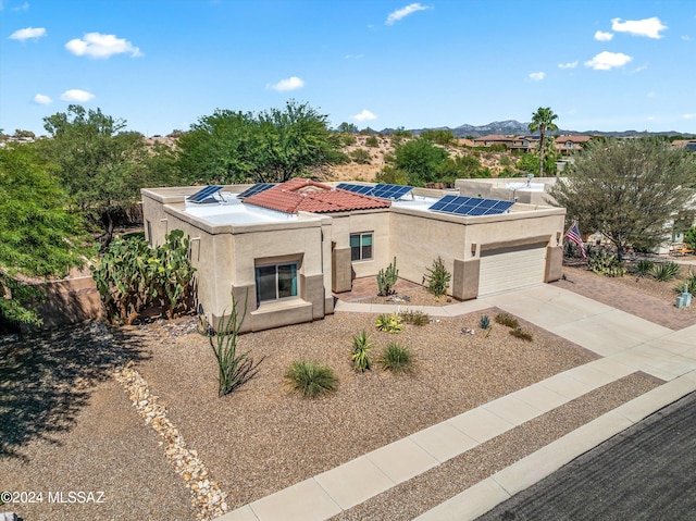 view of front of property featuring solar panels and a garage