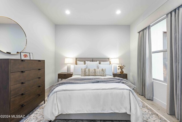 bedroom with light wood-type flooring and multiple windows