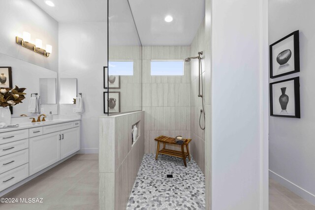 bathroom with vanity, tiled shower, and tile patterned floors