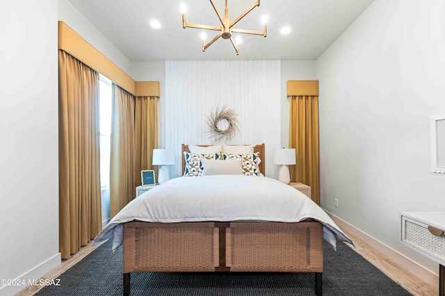 bedroom featuring hardwood / wood-style floors and an inviting chandelier