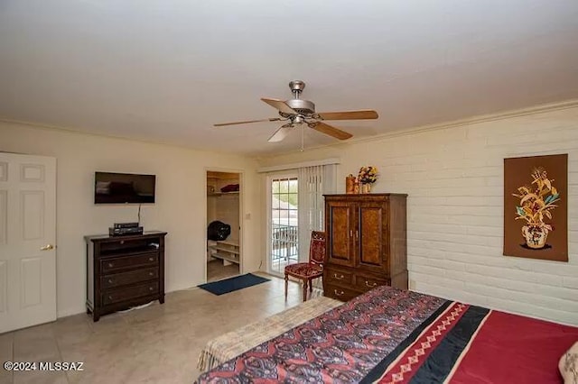 bedroom featuring access to outside, a walk in closet, ceiling fan, brick wall, and a closet