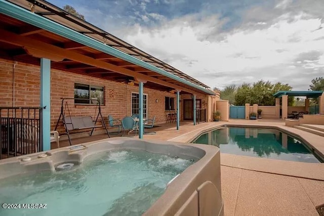 view of pool featuring a hot tub and a patio area