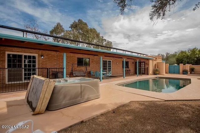 rear view of property featuring a fenced in pool and a patio area