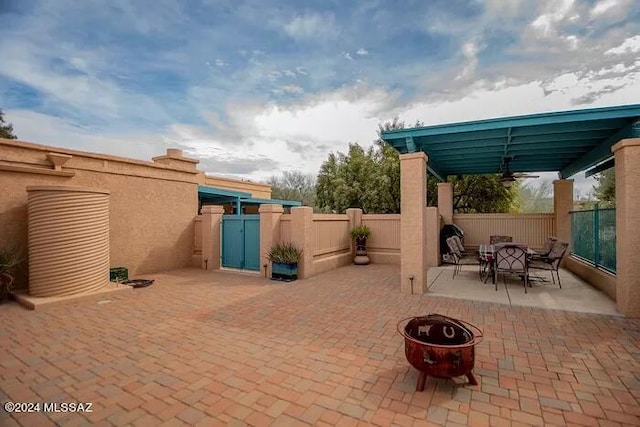 view of patio with ceiling fan and a fire pit