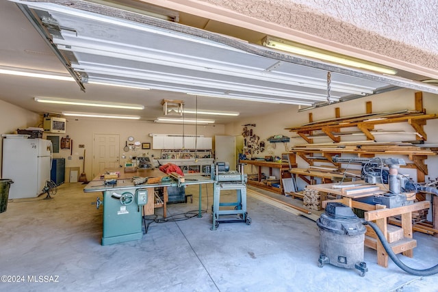 garage featuring white refrigerator and a workshop area