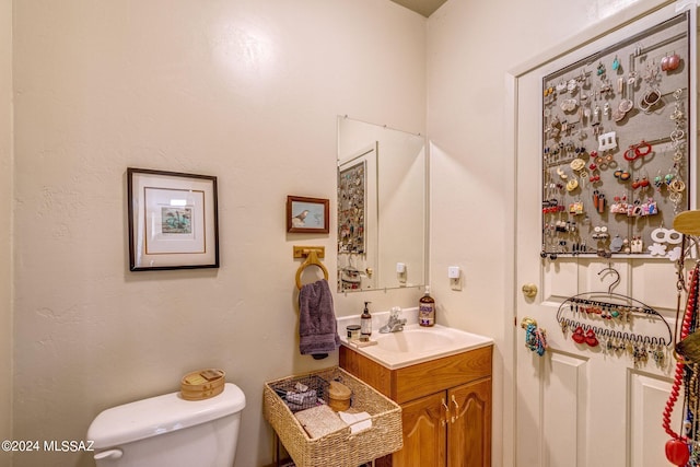 bathroom featuring tile patterned flooring, vanity, brick wall, and toilet