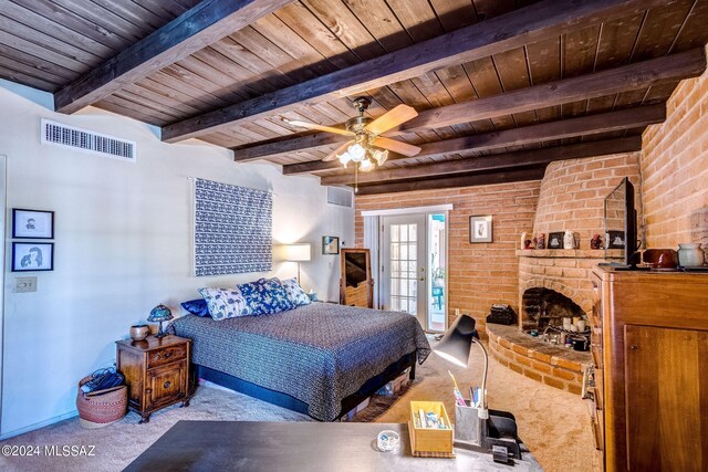 bedroom featuring beam ceiling, a fireplace, wooden ceiling, light colored carpet, and french doors