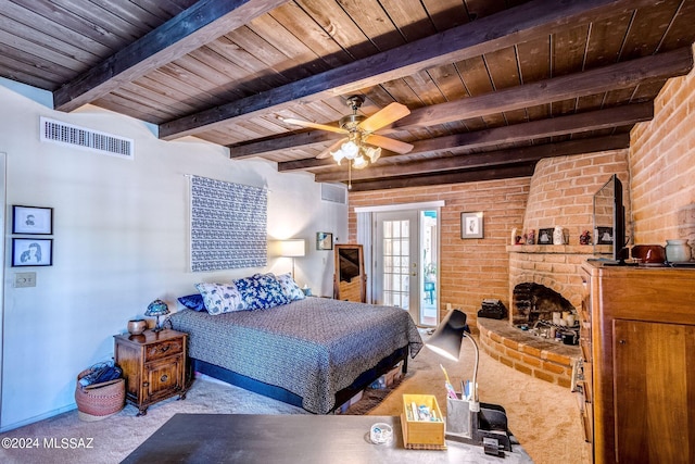 bedroom featuring ceiling fan, beamed ceiling, light carpet, a fireplace, and wood ceiling