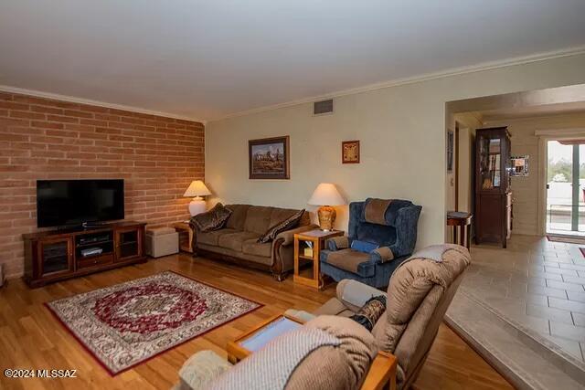 living room featuring light hardwood / wood-style floors and crown molding