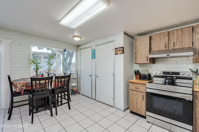 kitchen with light tile patterned floors and stainless steel range with electric cooktop