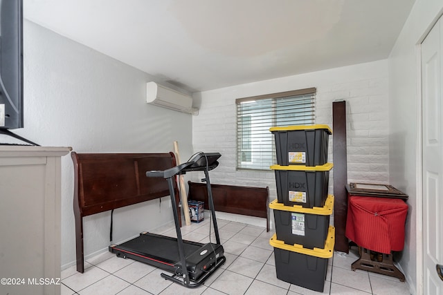 workout room with a wall mounted AC, light tile patterned floors, and brick wall