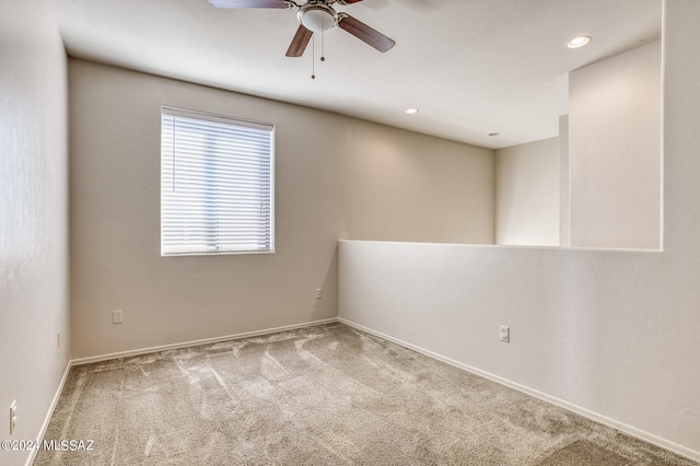 carpeted spare room with ceiling fan