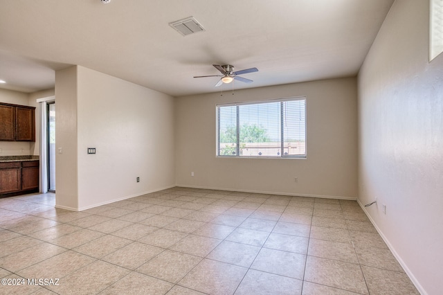 tiled spare room with ceiling fan