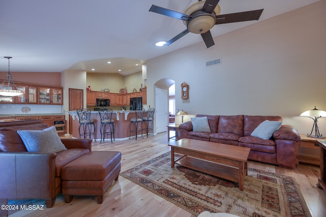 living room with light hardwood / wood-style flooring, ceiling fan, and lofted ceiling