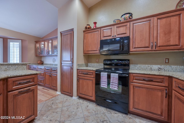 kitchen featuring black appliances, light stone countertops, light hardwood / wood-style flooring, and vaulted ceiling