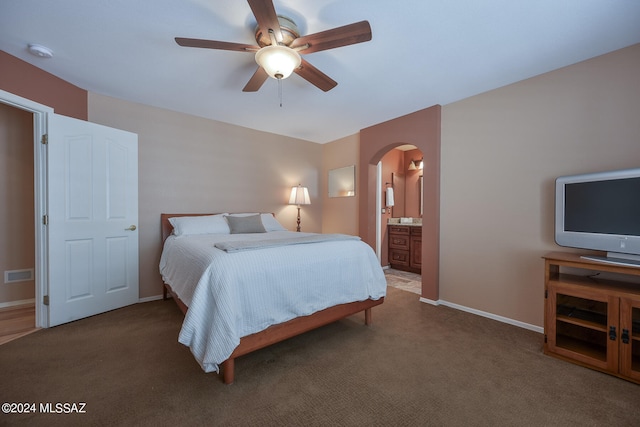 carpeted bedroom with connected bathroom and ceiling fan