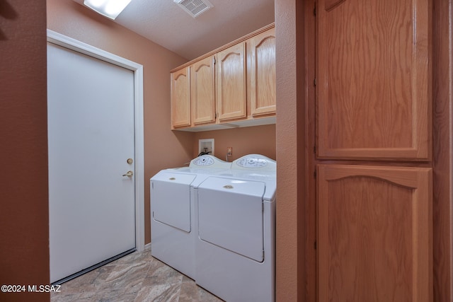 washroom with cabinets, separate washer and dryer, and a textured ceiling