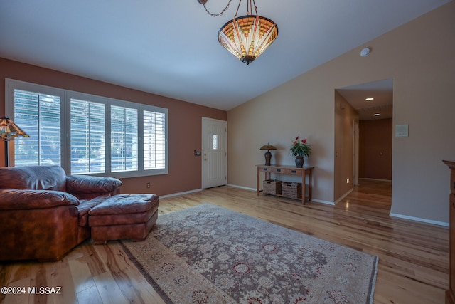 living room with light hardwood / wood-style floors and lofted ceiling