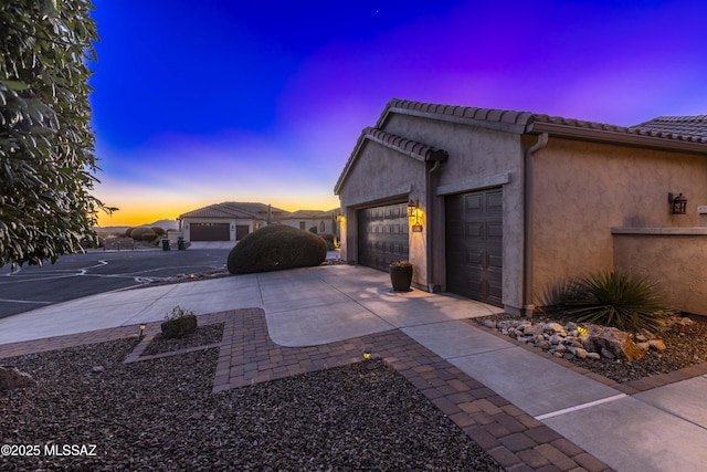 property exterior at dusk featuring a garage