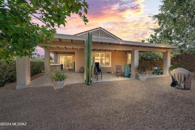 back house at dusk with a patio