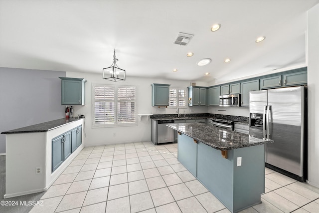 kitchen with stainless steel appliances, sink, light tile patterned floors, decorative light fixtures, and lofted ceiling