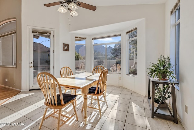 tiled dining room with lofted ceiling, a mountain view, and ceiling fan