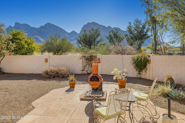 view of patio / terrace featuring a mountain view and an outdoor fire pit