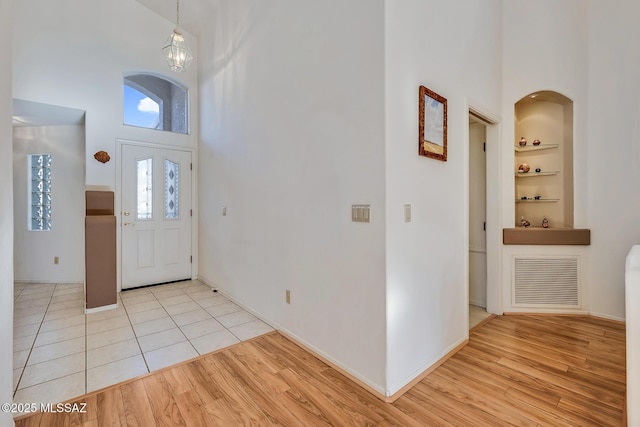 entryway with sink, a high ceiling, and light wood-type flooring