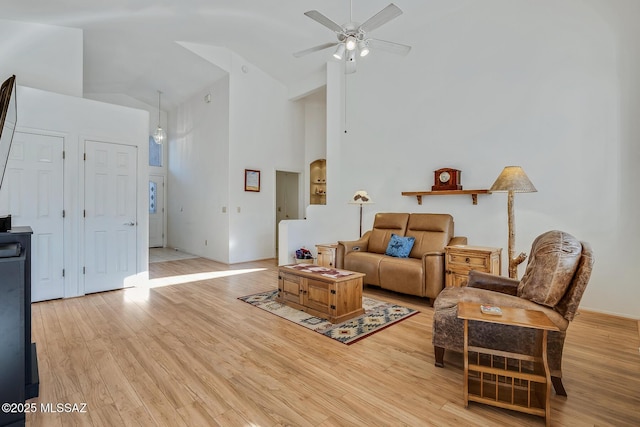 living room featuring ceiling fan, high vaulted ceiling, and light hardwood / wood-style flooring