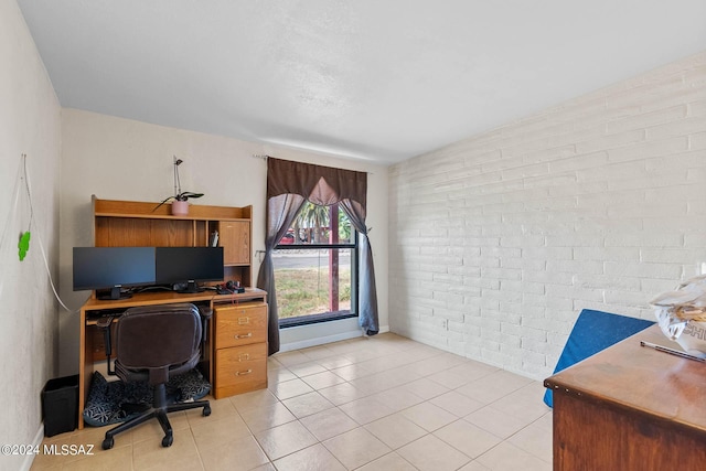 office area with baseboards, light tile patterned floors, and brick wall