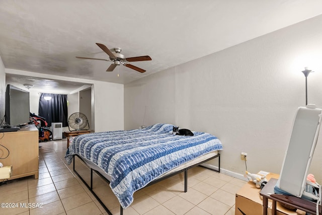 bedroom with light tile patterned flooring, ceiling fan, and baseboards