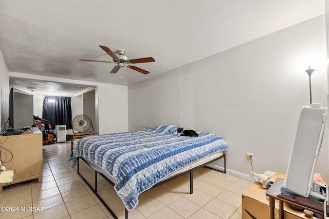 bedroom with light tile patterned floors, baseboards, and a ceiling fan