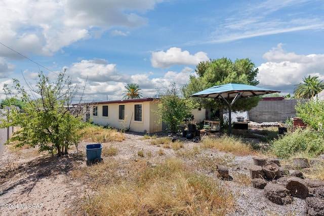 back of property with stucco siding and fence