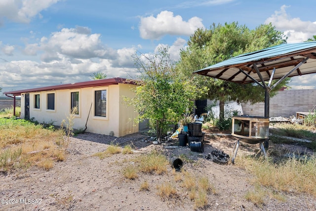 rear view of house with fence and stucco siding