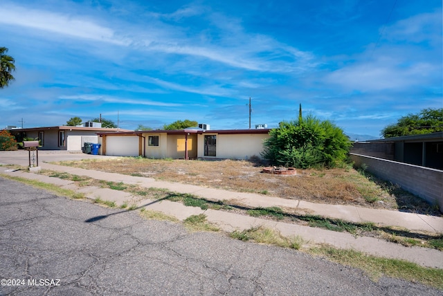 ranch-style home with an attached garage, stucco siding, and concrete driveway