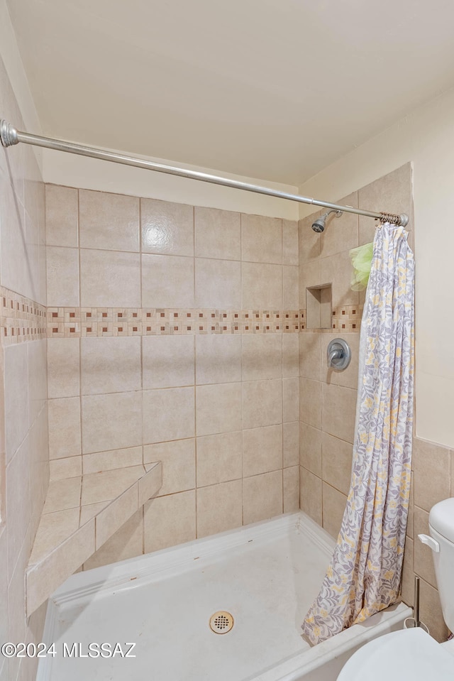 bathroom featuring tile walls, toilet, and a shower with curtain