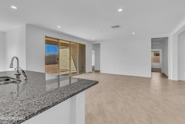 kitchen featuring sink and dark stone counters