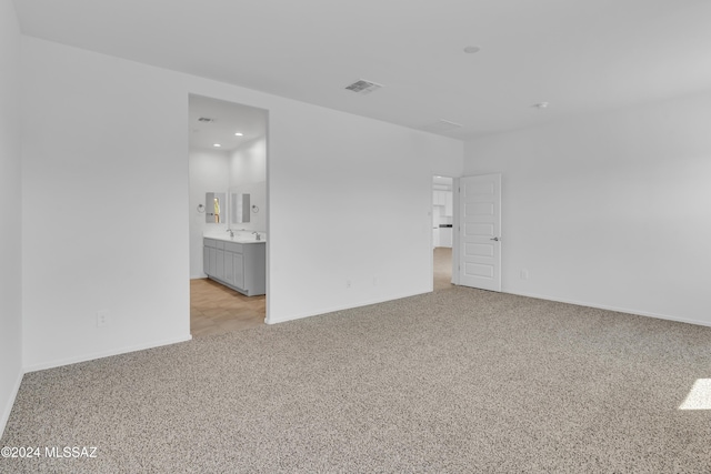 unfurnished room featuring light carpet