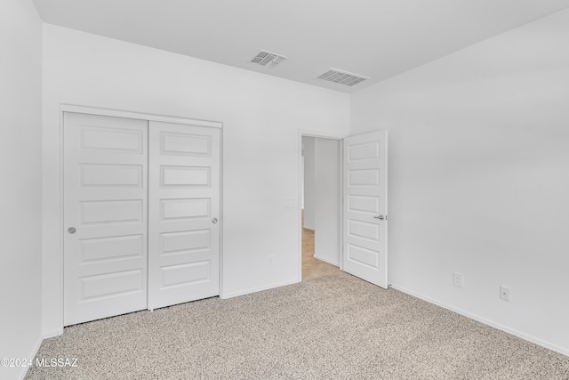 unfurnished bedroom featuring carpet flooring and a closet