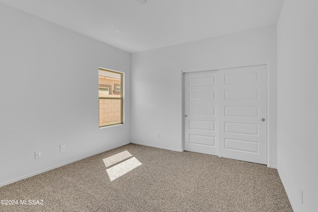 unfurnished bedroom featuring carpet and a closet