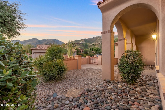 yard at dusk with a mountain view and a patio area