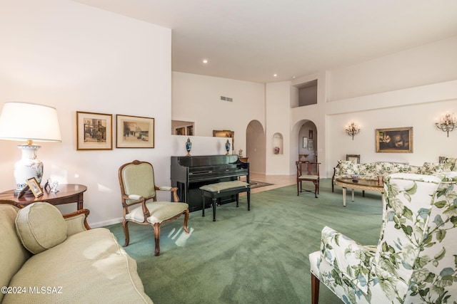 carpeted living room with a towering ceiling