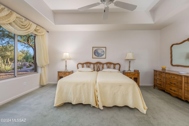 bedroom with a tray ceiling, ceiling fan, and carpet