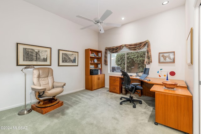 office space featuring light carpet, a towering ceiling, and ceiling fan